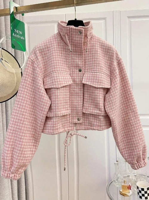 Pink and cream checked utility jacket on a hanger, showing a raised drawcord collar, chest flap pockets, front snap buttons, elasticated cuffs and a drawcord hem