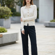 White long-sleeve shirt with buttons worn by a person, blurred background