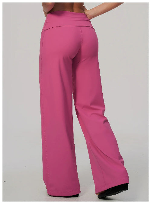 A person shown from the back wearing bright pink wide-leg pants against a plain light gray studio background.