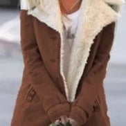 Front view of a woman wearing a brown coat with wide cream fleece-look lapels, cuff tabs and front pockets over a white top⠋