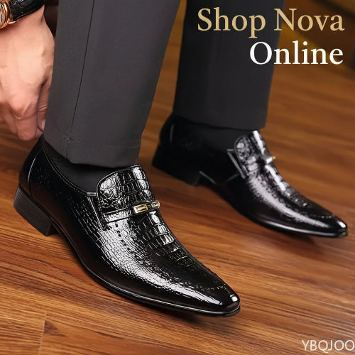 Black dress shoes with crocodile texture on a wooden floor