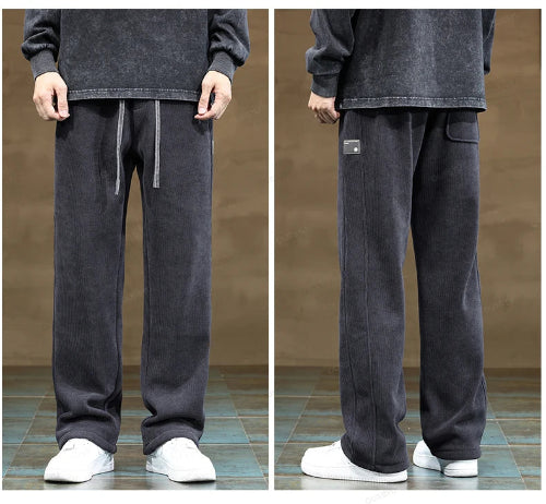 Dark gray sweatpants worn by a person on a brown background