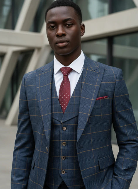 Man wearing a blue checkered suit with a red tie in an urban setting