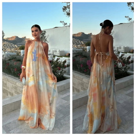 Woman wearing a long, colorful dress with a scenic background.