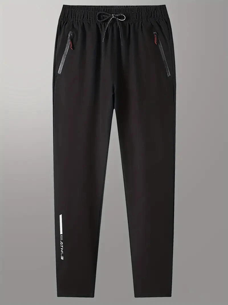 Black pants with side zippers on a gray background