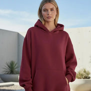 Maroon hoodie worn by a person on a white background