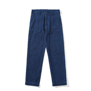 Front view of indigo sashiko fatigue pants with a button waist and large patch pockets against a white background.