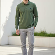 Green polo shirt with Ralph Lauren logo held by a hand against a blurred background