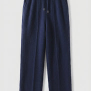 A pair of dark navy blue wide-leg trousers hanging 