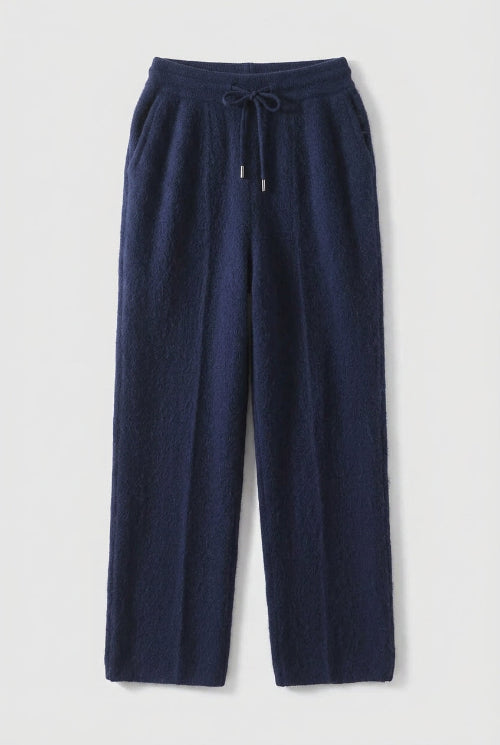A pair of dark navy blue wide-leg trousers hanging 