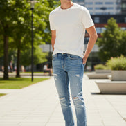 Pair of blue jeans with slight distressing on a white background