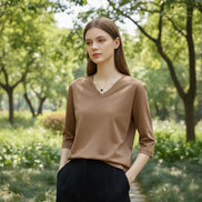 Mannequin wearing a beige V-neck shirt with text on a plain background