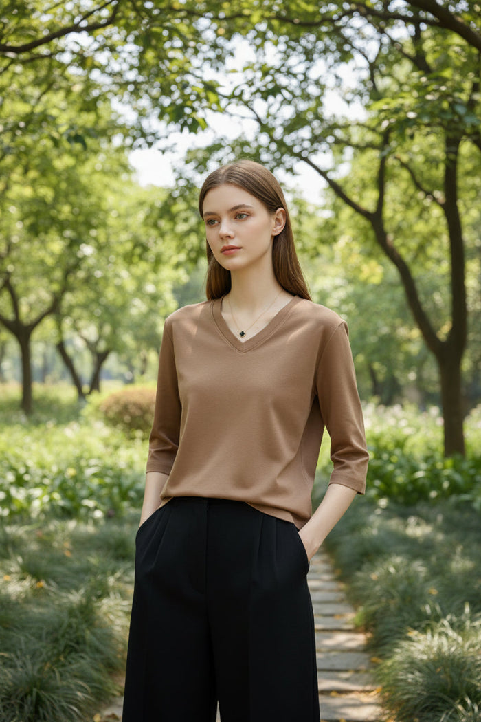 Mannequin wearing a beige V-neck shirt with text on a plain background