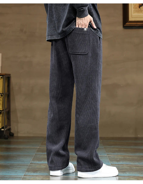 Person wearing dark gray wide-leg pants with a plain background