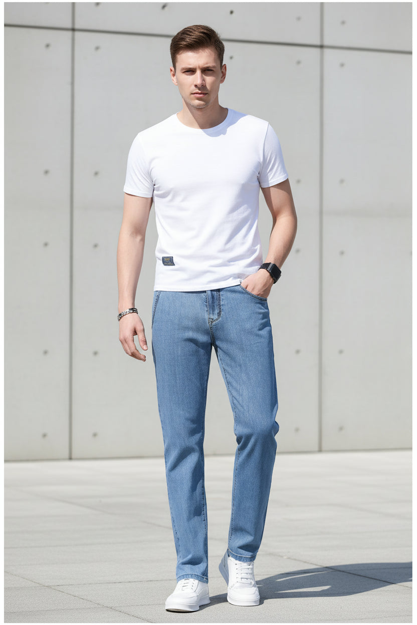 Person wearing light blue jeans and white sneakers on a blurred outdoor background