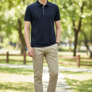 Navy blue polo shirt worn by a person on a gray background