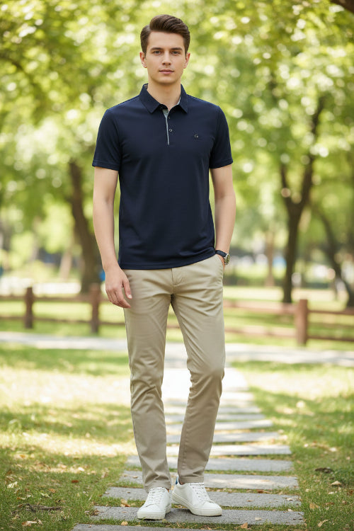 Navy blue polo shirt worn by a person on a gray background