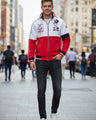 A men's colorblock zip-up jacket with a white upper chest, red lower body, and navy blue sleeve and collar accents.