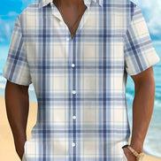Person wearing a blue and white plaid shirt with a beach background