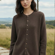 Person wearing a brown button-up cardigan in a clothing store setting