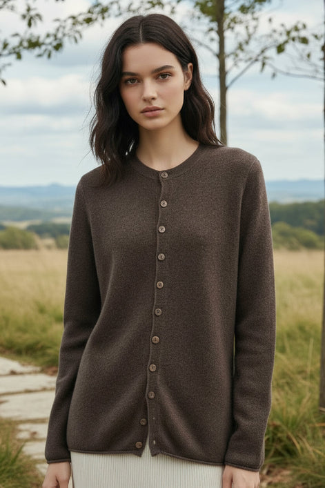 Person wearing a brown button-up cardigan in a clothing store setting