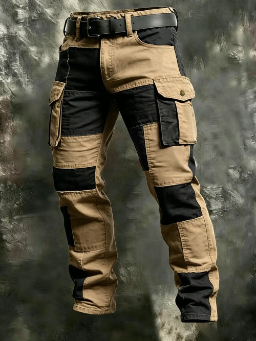 Khaki and black color-block cargo pants with flap thigh pockets and a black belt against a textured gray background.