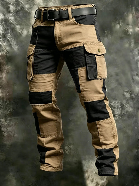 Khaki and black color-block cargo pants with flap thigh pockets and a black belt against a textured gray background.