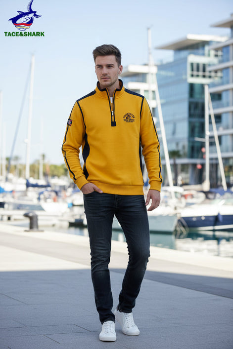 A men's long-sleeve quarter-zip pullover sweatshirt in bright yellow with black shoulder and sleeve stripes, featuring a mock neck collar, a chest zipper pocket, 