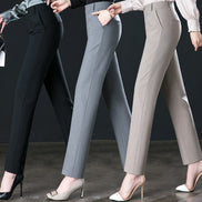 Three pairs of pants in black, gray, and beige worn by models against a dark background.