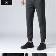 Dark gray pants worn by a person on a gray background