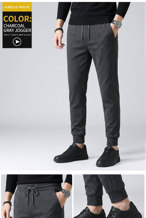 Dark gray pants worn by a person on a gray background