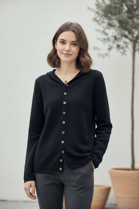 Person wearing a dark cardigan taking a mirror selfie in a clothing store.