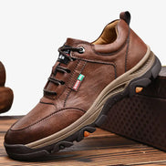Brown leather shoe with black sole on a wooden surface