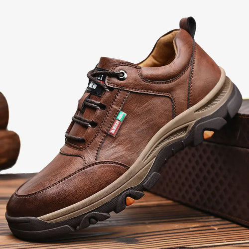 Brown leather shoe with black sole on a wooden surface