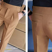 Close-up of beige pants with a focus on details against a blue background.