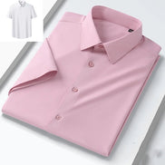 A folded light pink long-sleeve dress shirt with a pointed collar and matching buttons, shown on a clean white background.