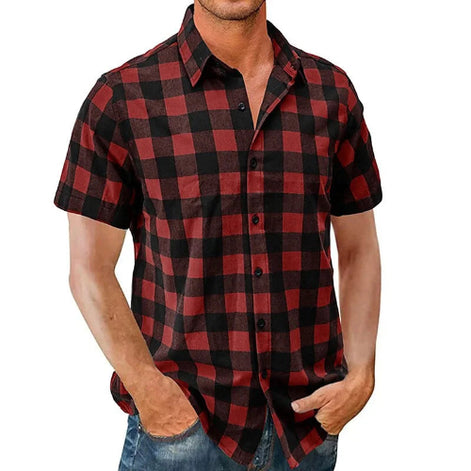 A man wearing a short-sleeve button-up shirt with a red and black buffalo plaid pattern, paired with blue jeans, shown against a plain white background.