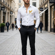 A man wearing a white long-sleeve button-up shirt with a gold embroidered horse and the words 'Success at first try' on the left 