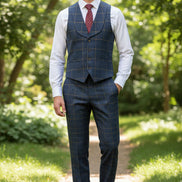 Blue checkered vest with a red tie on a mannequin against a beige curtain background