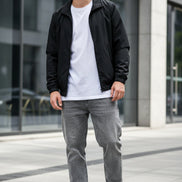 White sneakers with black and red accents on a gray textured surface