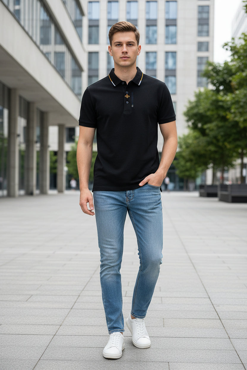 Black polo shirt with a brand logo held by a hand in a clothing store.
