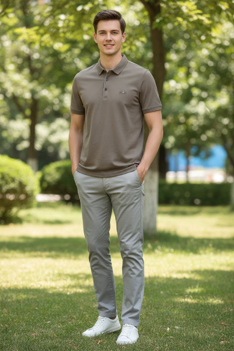 Brown polo shirt in a black box with a watch on a dark surface