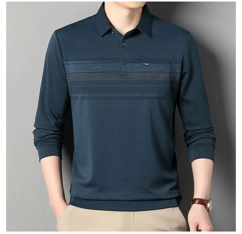 A man wearing a dark navy blue long-sleeve polo shirt with a subtle geometric pattern and horizontal textured stripes across the chest, paired with beige trousers.