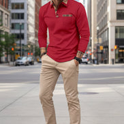 Man wearing a red long-sleeve shirt with plaid accents on a city street.