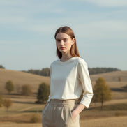 Person wearing a white long-sleeve shirt in a neutral setting