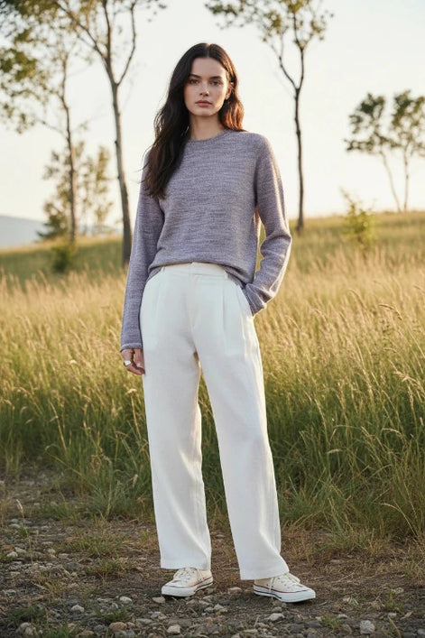 A woman wearing a textured knit long-sleeve sweater in a heathered dusty lavender-gray color, 