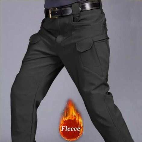 Front view of a model wearing dark gray cargo pants with flap thigh pockets and a black belt, alongside a fleece label graphic against a gray background.