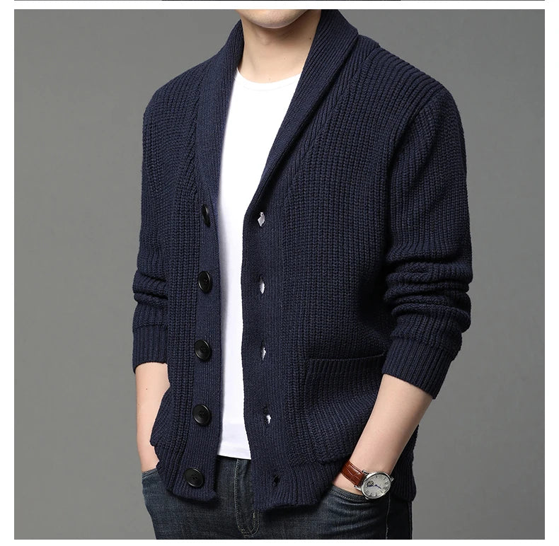 Navy blue cardigan worn by a person on a gray background
