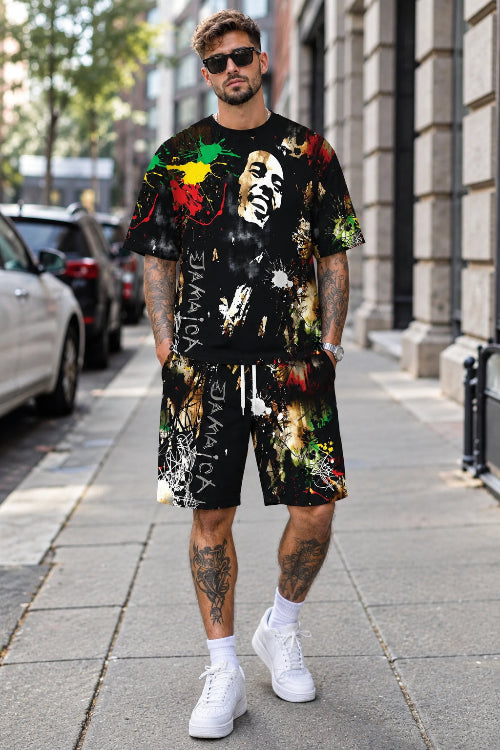 A man walking on a city sidewalk wearing a matching black graphic t-shirt and shorts set with a Bob Marley 
