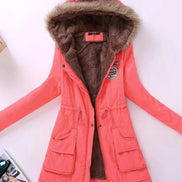 Coral winter coat with fur-lined hood on a light pink background